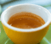 Espresso servito in una tazzina gialla su piattino verde presso CoffeeStorming.